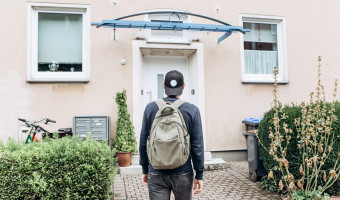 Young person facing a home in front of them