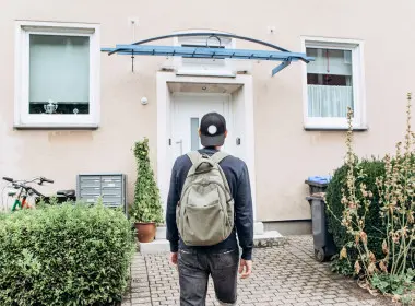 Young person facing a home in front of them