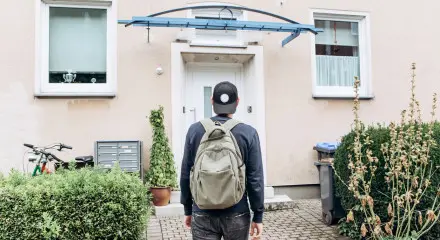 Young person facing a home in front of them