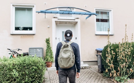 Young person facing a home in front of them