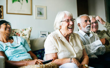 Four joyful older people reacting to an event from, the couch