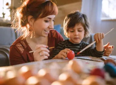 Young woman and a boy painting and crafting