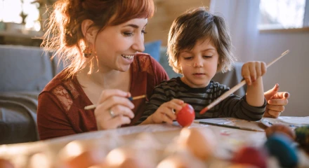 Young woman and a boy painting and crafting