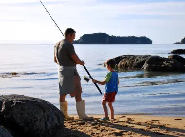 Father and son fishing on the shore