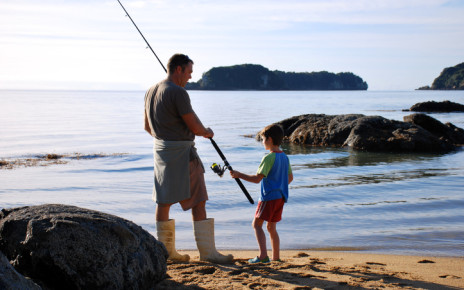 Father and son fishing on the shore