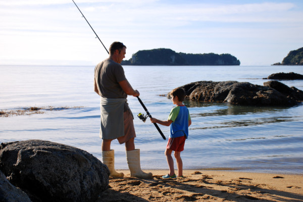 Father and son fishing on the shore