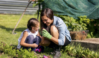 Young mother and daugher inspecting seeds while gardening