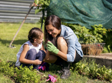 Young mother and daugher inspecting seeds while gardening