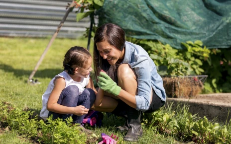 Young mother and daugher inspecting seeds while gardening
