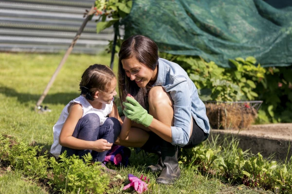 Young mother and daugher inspecting seeds while gardening