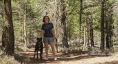 Ruth from the Happy Saver is pictured in a forest with a dog