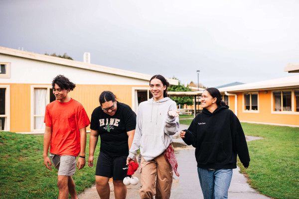 Four young adults are walking together looking happy