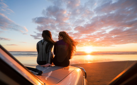 Two women on truck at beach 