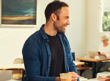 A man and woman are sitting together at a table in a cafe