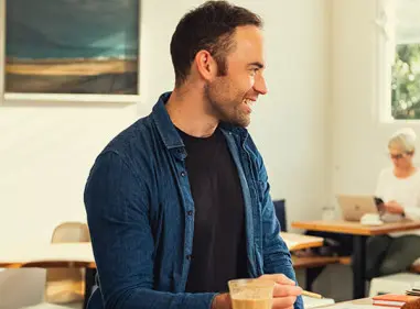 A man and woman are sitting together at a table in a cafe