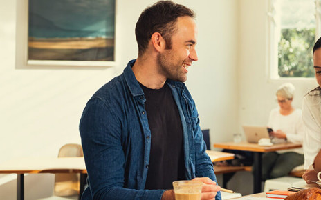 A man and woman are sitting together at a table in a cafe