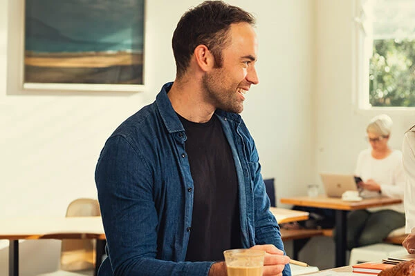 A man and woman are sitting together at a table in a cafe
