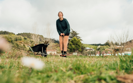Woman standing next to a wheelbarrow