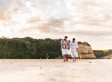 Family of three walking down a NZ beach talking about their why for having emergency savings
