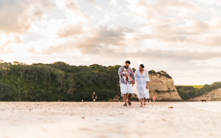 Family of three walking down a NZ beach talking about their why for having emergency savings