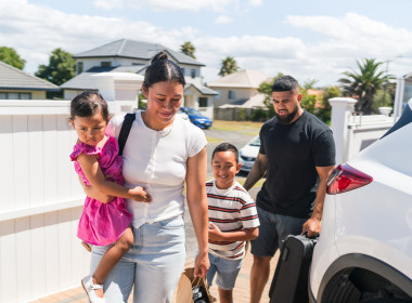 Family of four getting off a car thinking of their emergency savings.
