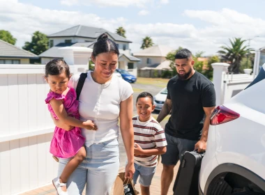 Family of four getting off a car thinking of their emergency savings.