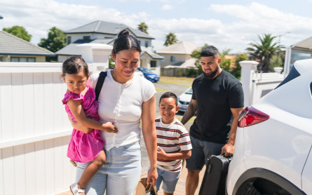 Family of four getting off a car thinking of their emergency savings.