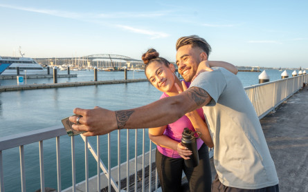 Couple taking a selfie by the Auckland Harbour Bridge