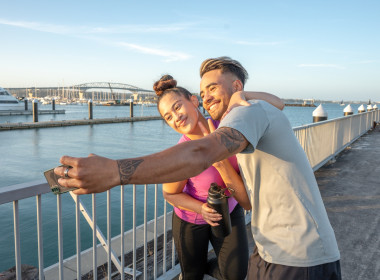 Couple taking a selfie by the Auckland Harbour Bridge
