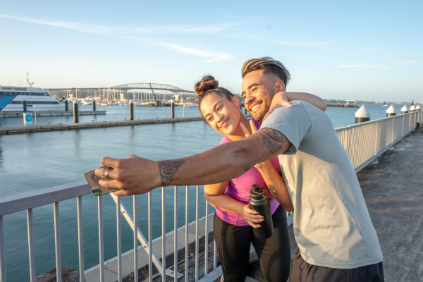 Couple taking a selfie by the Auckland Harbour Bridge
