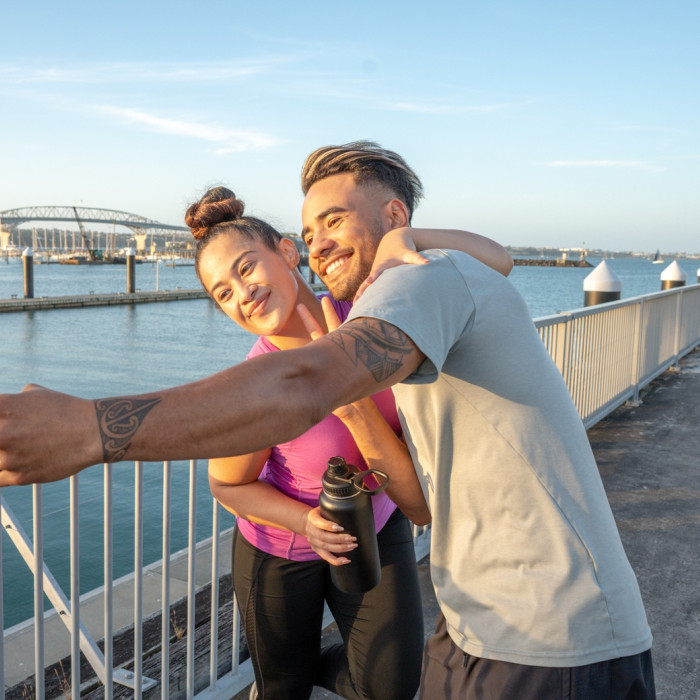 Couple taking a selfie by the Auckland Harbour Bridge