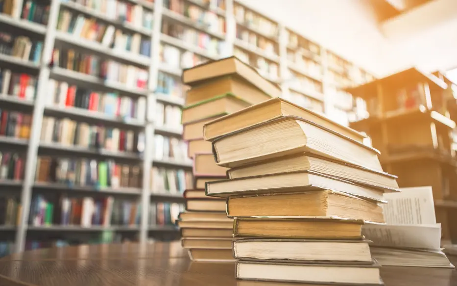 Close up of pile of books on a table in a library